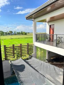 a porch of a house with a fence and a field at Navia in Sañgitan