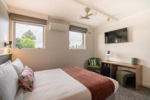 a bedroom with a bed and a desk and window at Doonside Hotel, Blacktown in Doonside