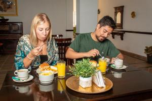 a man and woman sitting at a table eating food at Hotel Boulevard del Río in Cali
