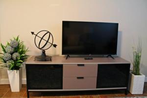 a flat screen tv sitting on top of a entertainment center at Red Bank Cozy Nest in Chattanooga