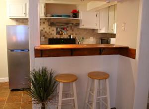 a kitchen with two bar stools and a refrigerator at Red Bank Cozy Nest in Chattanooga