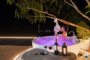 a woman in a bath tub with two glasses of wine at Paradiso Khaokho By N in Ban Huai Phai