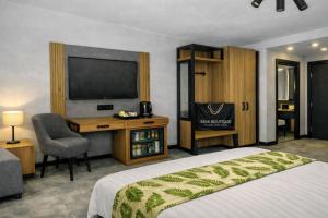 a hotel room with a bed and a desk and a television at Raya Boutique in Sunny Beach