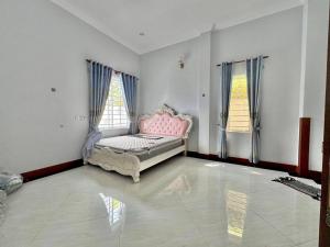 a bedroom with a pink bed in a room with windows at Chakra Rauniyar in Kathmandu