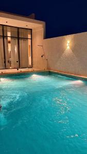 a swimming pool with blue water in front of a building at رجبانية in Jeddah +5 photos