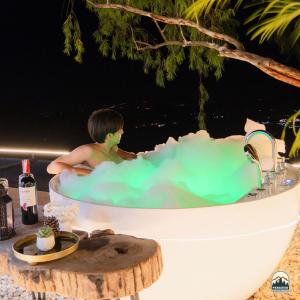 a young boy in a bathtub with green water at Paradiso Khaokho By N in Ban Huai Phai +28 photos