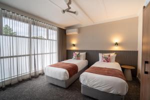 a hotel room with two beds and a window at Doonside Hotel, Blacktown in Doonside