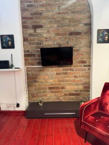 a living room with a brick wall with a tv at al home in Crema