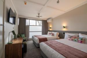 a hotel room with two beds and a television at Doonside Hotel, Blacktown in Doonside +1 photo