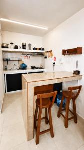a kitchen with a wooden counter and two stools at Casa paz in Isla Mujeres