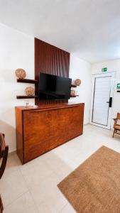 a living room with a flat screen tv on a desk at Casa paz in Isla Mujeres