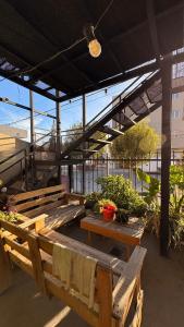 a group of wooden benches sitting under a building at Hostel Maranata in Puerto Madryn