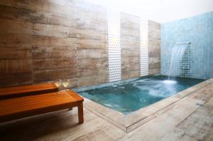 bañera de hidromasaje con banco y fuente de agua en Zaya Motel Premium en Florianópolis