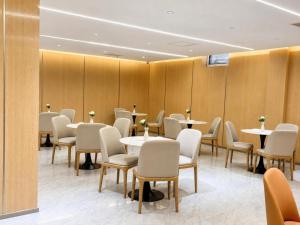 a dining room with tables and chairs in a room at Bishkek Crystal Luxury Smart Hotel Ala-Too Square Branch in Bishkek