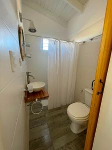 a bathroom with a toilet and a sink at Templanza in Villa Yacanto +2 photos