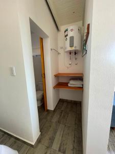 a bathroom with a toilet and a dryer on a wall at Templanza in Villa Yacanto