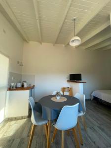 a dining room with a black table and blue chairs at Templanza in Villa Yacanto