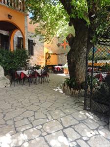 un patio con mesas, sillas y un árbol en Rooms Marko Polo, en Zadar