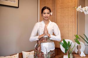 a woman doing a gesture with her hands at Dahayu Villa Ubud in Ubud