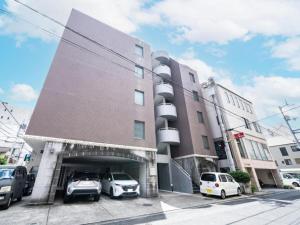 a building with cars parked in a parking lot at NicoRoom601-Convenient location in Takamatsu +23 photos