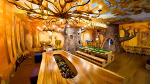 a room with a table and trees on the ceiling at GREENHILLS RESORT Si Racha in Ban Nong Wa