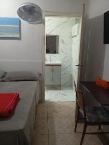 a bedroom with a bed and a bathroom with a sink at Pousada Hostel Brasil Gru in Guarulhos