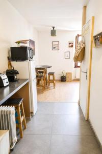 a kitchen and living room with a refrigerator and a table at T2 centre Ville Proche des pistes in Briançon