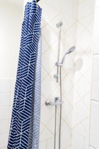 a shower with a blue and white shower curtain at T2 centre Ville Proche des pistes in Briançon +11 photos
