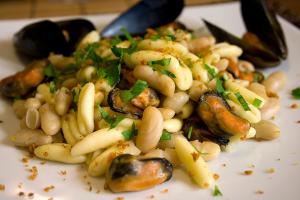 a white plate of food with mushrooms and vegetables at Hotel Vela Velo Club Vieste in Vieste