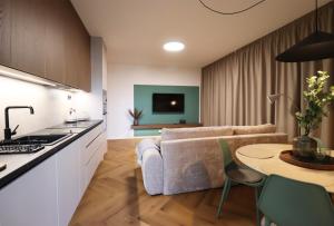 a kitchen and living room with a couch and a table at APARTMENT A&D Monaco in Poprad +20 photos