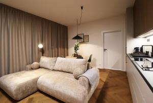 a living room with a couch and a kitchen at APARTMENT A&D Monaco in Poprad