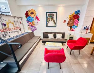 a room with a couch and two red chairs at Hotel y Arte Antigua by Amazing Guatemala Travel in Antigua Guatemala