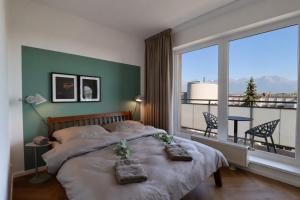 a bedroom with a bed and a large window at APARTMENT A&D Monaco in Poprad