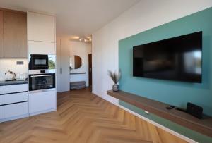 a kitchen with a large flat screen tv on a wall at APARTMENT A&D Monaco in Poprad
