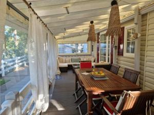 a porch with a table and chairs on a house at La Cabane de Nell in Lège-Cap-Ferret +20 photos