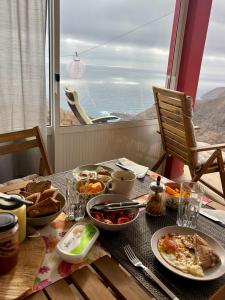 a table with breakfast food and a view of the ocean at Casa Terra Odjo N'mar in Janela