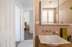 a bathroom with a sink and a mirror at Lovley sunlit apartment walking distance to Cronulla mall and Cronulla Beach in Cronulla +12 photos