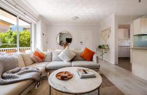 a living room with a couch and a table at Lovley sunlit apartment walking distance to Cronulla mall and Cronulla Beach in Cronulla