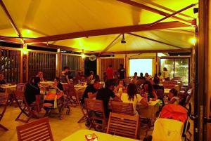 a group of people sitting at tables in a restaurant at Hotel Vela Velo Club Vieste in Vieste