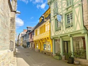 eine Straße in einer Altstadt mit gelben und weißen Gebäuden in der Unterkunft L'esprit forêt in Les Forges