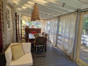 a screened in porch with a table and chairs at La Cabane de Nell in Lège-Cap-Ferret