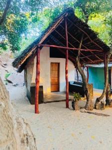 a small house with a thatched roof at Nilaveli Eco Lodge in Nilaveli