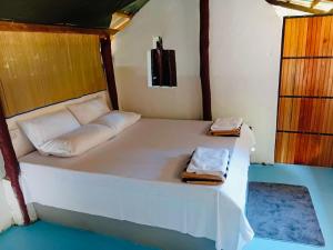 a bedroom with a white bed with two towels on it at Nilaveli Eco Lodge in Nilaveli