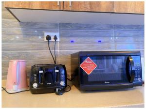 a microwave and a toaster oven sitting on a counter at Nyali Glam Apartment in Mombasa