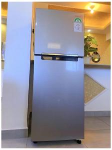 a stainless steel refrigerator sitting in a kitchen at Nyali Glam Apartment in Mombasa +1 photo