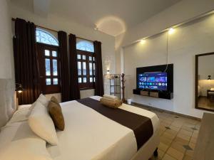 a bedroom with a large bed with a tv on the wall at Hotel Boulevard del Río in Cali