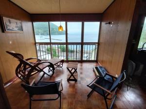 a living room with chairs and a large window at Kingfisher Lodge in Shodoshima +10 photos