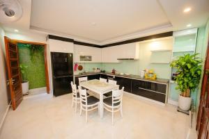 a kitchen with a table and chairs in a room at Cortis Homestay in Nà Rẻ