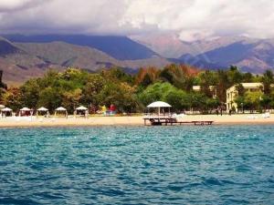 a beach with a pier and umbrellas in the water at Вилла Витязь in Chok-Tal
