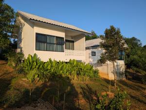 a house with plants in front of it at Loei Valley Farm Stay in Wang Saphung
